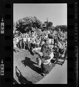 Two women hug while crowd cheers