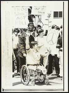 A Warrior's Peace -- Terry Frazier of Denver a legless Vietnam veteran was in the front line of marchers during a demonstration in Denver Thursday. Frazier lost both legs due to enemy action in Vietnam. Frazier carrying a "Peace" sign was pushed by a fellow-pupil from the University of Colorado. The march made its way through downtown Denver to the state capitol.