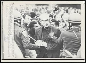 No Exceptions--A minister identified by police as Rev. Claire Nesmith,50, is grabbed by the lapels by an officer as he and others were placed under arrest during demonstrations on the San Francisco State College campus today. Minister at upper left in picture is Jerry Pedersen, Lutheran minister who was also arrested.