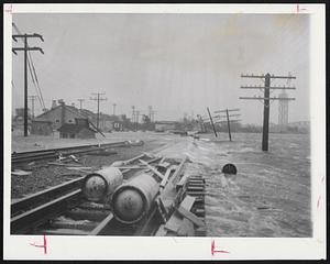 Under Water - This debris-scattered section of the New Haven's track at Buzzard's Bay was one of the chief reasons why service to the area was knocked out. Boats are also piled up on tracks.