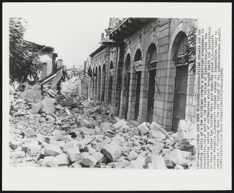 These Once Were Buildings-- Rubble-filled streets and the standing shells of a few buildings create a ghost-town atmosphere in Argostolion, chief port on the Greek island of Kefallinia, after the devastating series of earthquakes which brought death and destruction to three Ionian Sea islands this past week. The giant U.S. aircraft carrier Franklin D. Roosevelt dropped anchor at Argostolion today to serve as a floating base for air relief of the quake-stricken people.