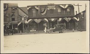 Car in front of flag-decorated Tarbell Block