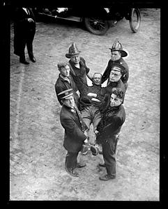 Firefighters and police hold an unidentified man