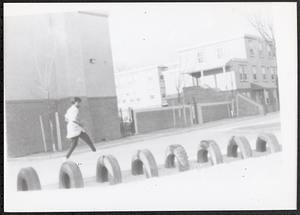 Young woman walking across a tire playground structure