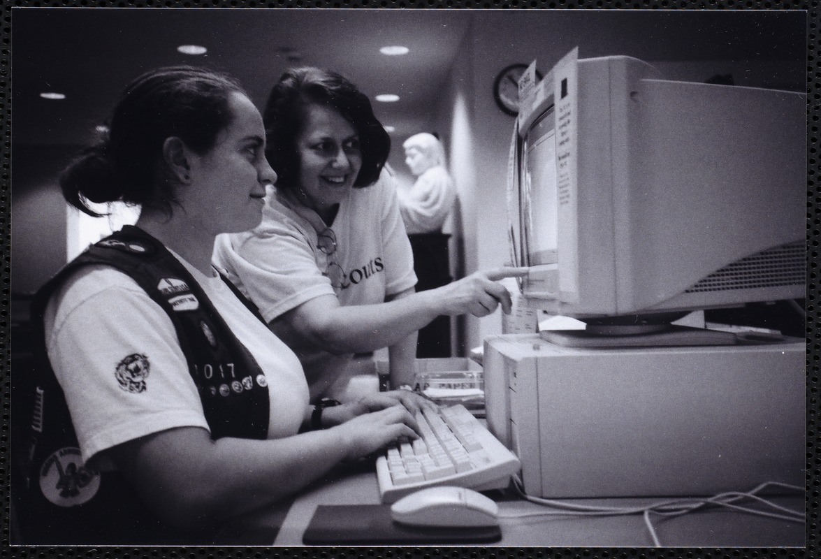 Newton Free Library, Newton, MA. Communications & Programs Office. Girl Scout leader & scout at computer terminal