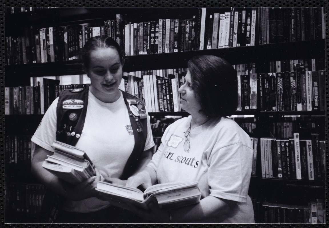 Newton Free Library, Newton, MA. Communications & Programs Office. Girl Scout leader & scout looking at book