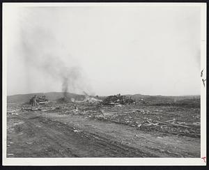 Tornado Aftermath-The beginnings of a trailer camp (above) sprout at Worcester near the tornado-smashed Lincolnwood housing project. Hundreds more trailers are due here for the homeless. Below: Workmen burn some of the splintered ruins of homes.