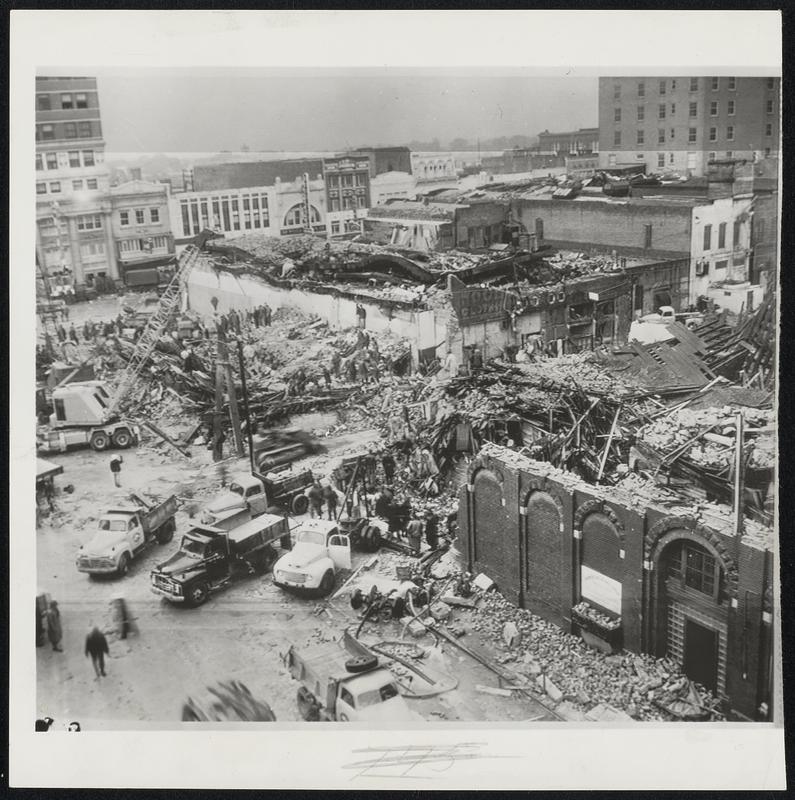 Cleaning Up Tornado Damage-Civilian, Army and Air Force workers, bolstered by heavy equipment, at work at gigantic task of cleaning up wreckage left by tornado that took at least 90 lives. This is the downtown area devastated by Monday's twister.