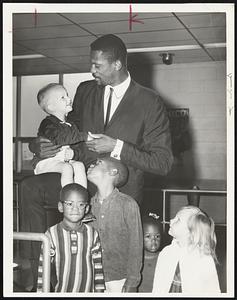 Celtics star Bill Russell chats with Jerry Schumacher, 2, of Brockton, prior to leaving Boston for Mississippi. Also seeing Russel of were his children, left to right, Jacob, 5, and William Jr., 6.