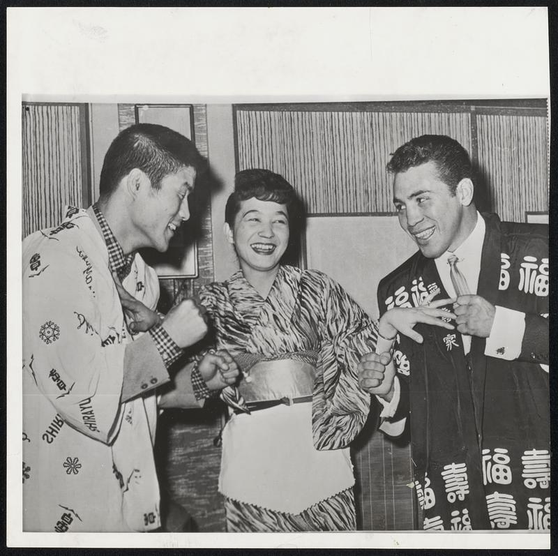 Getting Acquainted before their bout Thursday night at Los Angeles are Japanese welterweight champion, Jiro Sawada, left, who will be making his U. S. debut against Alvaro Guiterrez of Mexico. Waitress Hideko Takano keeps the theme light.