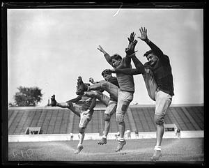 A group of football players mid kick
