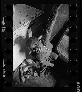 Child in overcrowded, black-owned, inner-city slum tenement