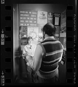 Two people stand in front of college and career posters