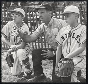 Two Little League players, man between them