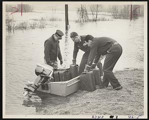 Three men loading gas cannisters into motorboat