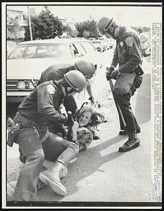 Police subdue demonstrator they caught after a group of protesters went on a rampage through a nearby shopping center, following a demonstration at San Francisco State College, which is adjacent to the campus.