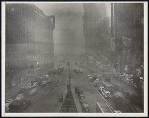 New York City-No, just the cross-roads of the world. A view of Times Square shortly after 3 o'clock July 12 as rain drenched the city, ending sweltering heat. Automobiles with their headlights turned on and theatres with their electric signs lighted are seen in the picture which was taken from the Times Building.