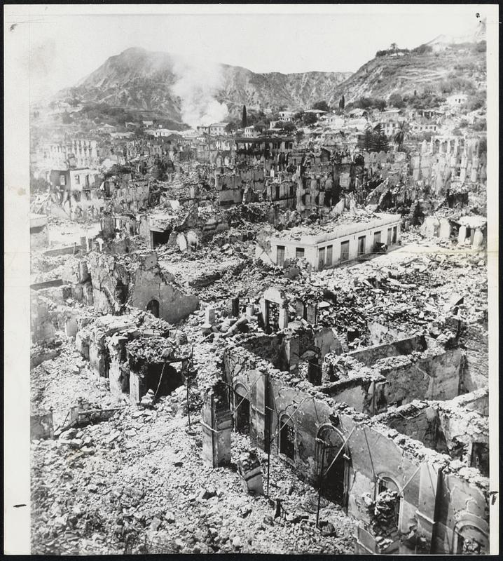 Graveyard of a Greek City-Not a living thing is visible amid the rubbled buildings of Zakinthos, one of the Greek island communities destroyed in last week's series of earthquakes. Smoke still rises from a burning building in this low-level air view by Associated Press staff photographer Eddie Worth.