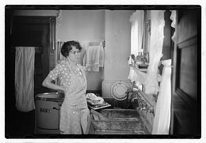 A woman doing laundry at a sink