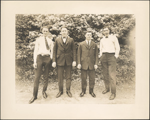 Four men standing in front of flowering plants