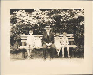 Man sitting on bench with four children