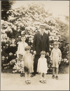 Man with four children in front of flowering plants