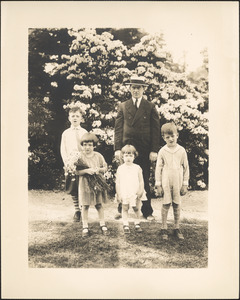 Man with four children in front of flowering plants