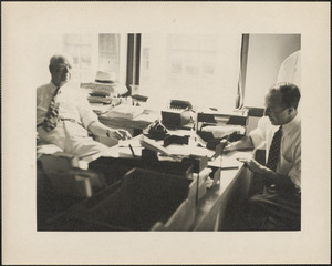 Two men at desk doing paperwork