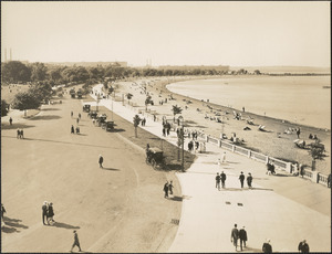 People walking along path and lounging on beach