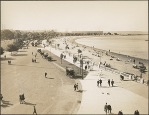 People walking along path and lounging on beach