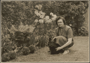 Woman with dog next to flowers