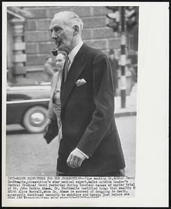 Witness For The Prosecution – Pipe smoking Dr. Arthur Henry Douthwaite, prosecution’s star medical expert, walks outside London’s Central Court yesterday during luncheon recess of murder trial of Dr. John Bodkin Adams. Dr. Douthwaite testified today that wealthy Mrs. Edith Alice Morrell, whom Dr. Adams is accused of drugging to death, apparently developed immunity to morphine and heroin just before she died.