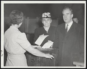 Kerrigans Vote - Mayor John E. Kerrigan and his mother, Mrs. Arnie Kerrigan, cast their votes at the Patrick Gavin school in Ward 7, Precinct 7, South Boston, with Mrs. Ida Harrison, elections inspector, standing by. The mayor's mother was the 34th voter to visit this polling place, and the mayor was 35th.