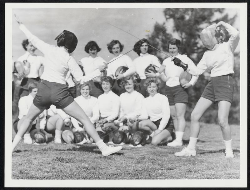 Two young women fencing