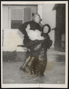 Eighty-year-old Emma Post is shown being carried to safety by C. E. McChesney, of the Virginia Beach Coast Guard, as a hurricane threatened to resort at Virginia Beach, Va.