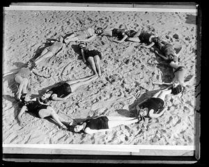 Women on a beach form a circle