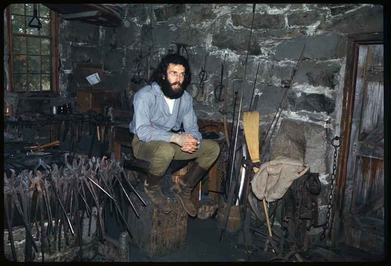 Man sitting in blacksmith shop, Old Sturbridge Village, Sturbridge, Massachusetts