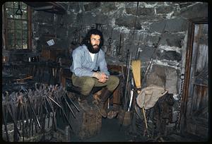 Man sitting in blacksmith shop, Old Sturbridge Village, Sturbridge, Massachusetts