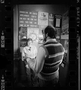 Two people stand in front of college and career posters