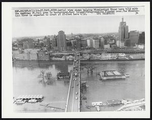 Aerial view shows bulging Mississippi River here 4/13 with the downtown St. Paul area in background. Navy Island (foreground) is flooded over. The Mississippi River is expected to crest at 27-feet here 4/16.