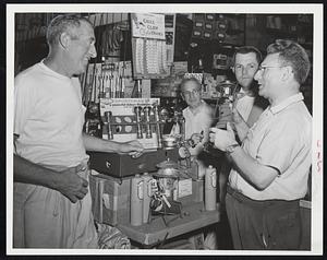 Hardware Salesman John Segel (right) sells a hurricane lamp to a customer who prefers not to take chances with capricious Hurricane Connie. What the storm will do is still a guess but New Englanders are battening down and getting supplied-just in case.