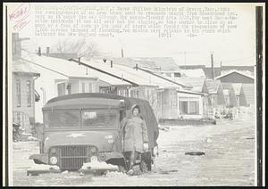Mayor William Reinstein of Revere, Mass. rides the running-board of an Army truck used to evacuate people from Broadsound Ave. here as it makes its way through the ocean-flooded are 2/20. For most Massachusetts residents it was all over but the digging, as they worked to clean up as much of a foot of snow in the wake of storm which forced the evacuation of some 2,000 persons because of flooding. Two deaths were related to the storm which battered the New England coast.