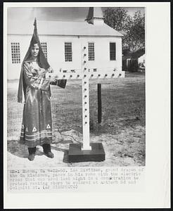 Lee Davidson, grand dragon of the Ga klansmen, poses in his robe with the electric cross that was used last night in a demonstration to protest renting store to colored at Antioch Rd and Colquitt St.