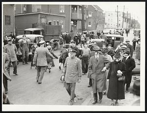 Miss Zara duPont, extreme right foreground, of Cambridge, 70-year-old member of the famous Delaware family, leading a group of gas-masked pickets past an Everett oil plant where tear gas was released in the rioting Tuesday.