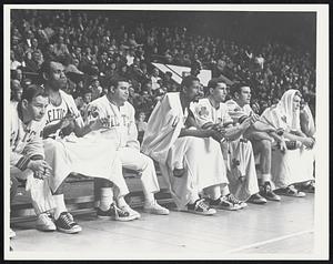 Bill Russell seated next to his Celtics teammates on the bench