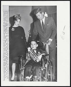 Poster Boy Visits -- President Kennedy poses at the White House today with 6-year-old Jimmy Boggess of Coy, Ark., the 1963 March of Dimes Poster Boy. At left is Jimmy's mother, Shirley Boggess. Jimmy wears leg braces and can walk slowly with the aid of crutches after two operations, performed to correct birth defects.