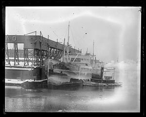 USS Topeka, a tugboat next to it