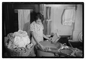 A woman doing laundry with a washing machine