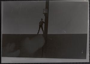 Jimmy Driscoll standing and holding onto a pole