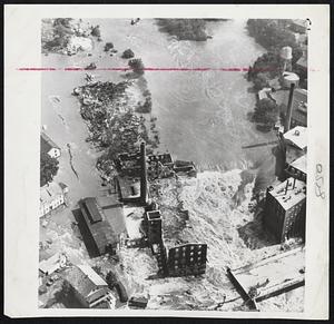 Fire Ruins Factory in Flood- Quinebaug River races past destroyed Putnam, Conn., magnesium factory which burned at height of flood Friday.